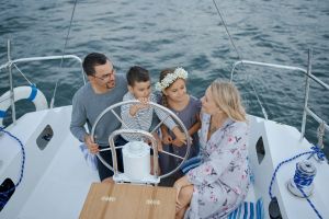 A family enjoying a peaceful day sailing on a yacht in the summer sea.