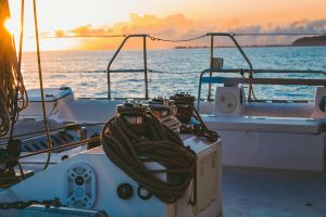A serene view of a yacht deck during sunset in French Polynesia's Windward Islands.