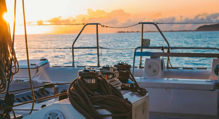 A breathtaking ocean sunset with vibrant pink and purple hues reflecting on calm waters, creating a serene atmosphere.